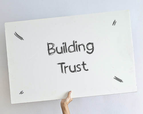 Building trust in Sales - Hand holding a whiteboard saying Building Trust